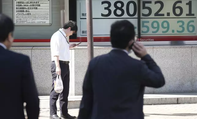 People stand in front of an electronic stock board showing Japan's Nikkei index at a securities firm Wednesday, Oct. 2, 2024, in Tokyo. (AP Photo/Eugene Hoshiko)