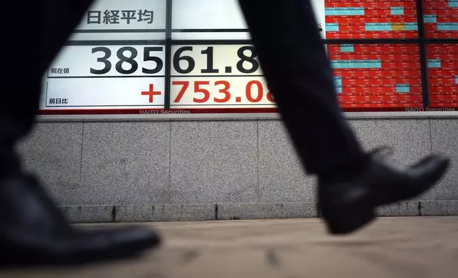 A person walks in front of an electronic stock board showing Japan's Nikkei index at a securities firm Thursday, Oct. 3, 2024, in Tokyo. (AP Photo/Eugene Hoshiko)