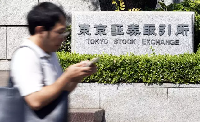 FILE - A person walks in front of the Tokyo Stock Exchange building Wednesday, Oct. 2, 2024, in Tokyo. (AP Photo/Eugene Hoshiko, File)