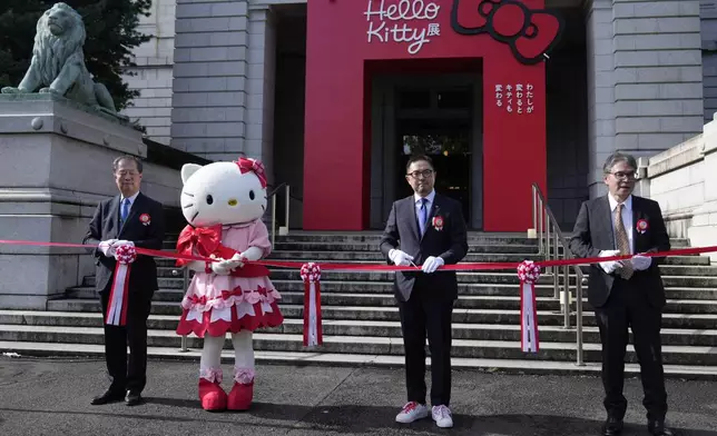 Hello Kitty, second from left, with Makoto Fujiwara, executive director of the Tokyo National Museum, left, Sanrio Senior Managing Director, Yasuyuki Otsuka, second right, and Keiichi Sawa, right, managing director of Nippon TV, attends the opening ceremony of the exhibition "As I change, so does she," marking the 50th anniversary of Hello Kitty at the Tokyo National Museum in Tokyo Wednesday, Oct. 30, 2024. (AP Photo/Shuji Kajiyama)