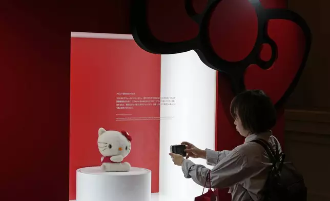 A visitor takes a picture of a Hello Kitty doll at the exhibition "As I change, so does she," marking the 50th anniversary of Hello Kitty at the Tokyo National Museum in Tokyo Wednesday, Oct. 30, 2024. (AP Photo/Shuji Kajiyama)