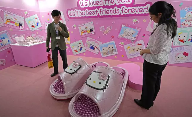 Visitors react to gigantic Hello Kitty slippers at the exhibition "As I change, so does she," marking the 50th anniversary of Hello Kitty at the Tokyo National Museum in Tokyo Wednesday, Oct. 30, 2024. (AP Photo/Shuji Kajiyama)