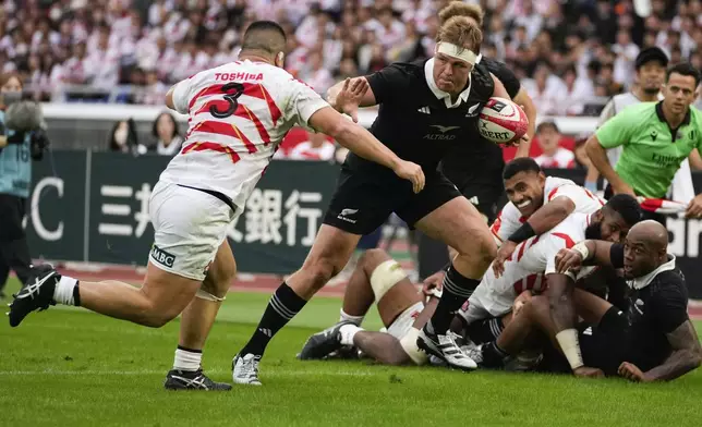 New Zealand's Sam Cane runs to the try line as Japan's Shuhei Takeuchi, left, attempts a tackle during a rugby test match between the All Blacks and Japan at Nissan Stadium in Yokohama, near Tokyo, Saturday, Oct. 26, 2024. (AP Photo/Shuji Kajiyama)