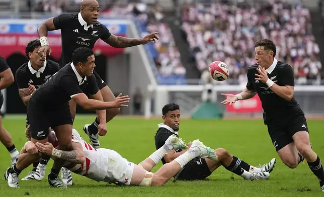 New Zealand's Cam Roigard, right, takes a pass from teammate Billy Proctor during a rugby test match between the All Blacks and Japan at Nissan Stadium in Yokohama, near Tokyo, Saturday, Oct. 26, 2024. (AP Photo/Shuji Kajiyama)