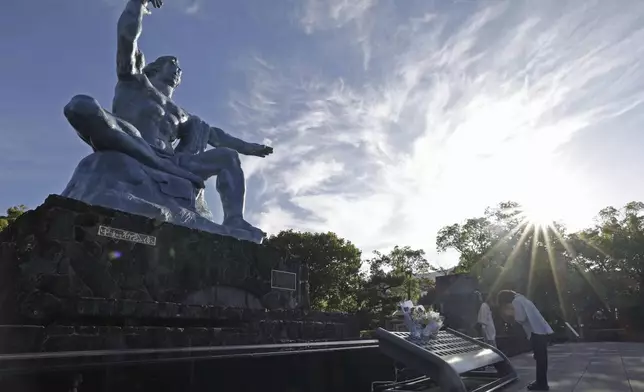 A visitor prays in front of the Peace Statue at the Peace Park in Nagasaki, southern Japan Saturday, Oct. 12, 2024, a day after the Nobel Peace Prize was awarded to Nihon Hidankyo, a Japanese organization of survivors of the U.S. atomic bombings of Hiroshima and Nagasaki, for its activism against nuclear weapons. (Kyodo News via AP)