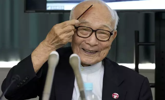 Terumi Tanaka, co-chairperson of Nihon Hidankyo smiles, combing his hair, ahead of a press conference in Tokyo, Saturday, Oct. 12, 2024, a day after Nihon Hidankyo, an organization of survivors of the two U.S. atomic bombings, won the Nobel Peace Prize. (AP Photo/Hiro Komae)