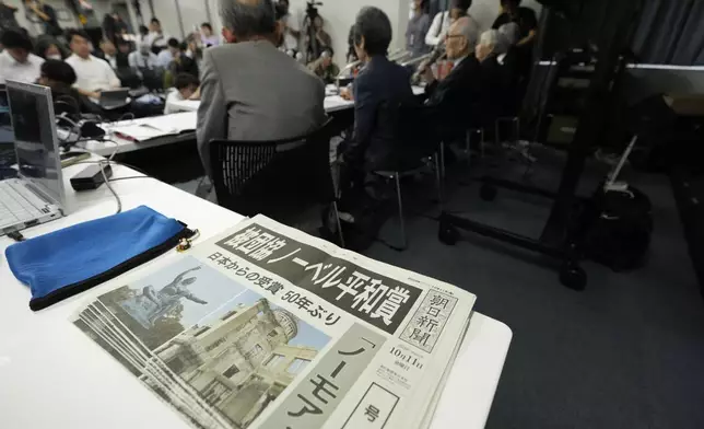 Copies of an extra version of Asahi Shimbun newspaper with the headline "Hindakyo wins Nobel Peace Prize" lie on a table during a press conference in Tokyo, Saturday, Oct. 12, 2024, a day after Nihon Hidankyo, an organization of survivors of the two U.S. atomic bombings, won the Nobel Peace Prize. (AP Photo/Hiro Komae)