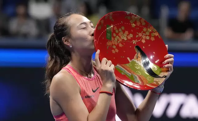 China's Zheng Qinwen kisses her trophy after winning the Pan Pacific Open women's tennis tournament at Ariake Coliseum, in Tokyo, Sunday, Oct. 27, 2024. (AP Photo/Eugene Hoshiko)