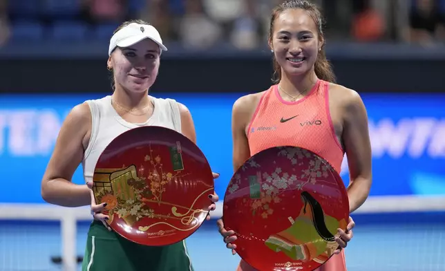 China's Zheng Qinwen, right, and Sofia Kenin of the United States pose with their trophies after winning the first and second place respectively in the Pan Pacific Open women's tennis tournament at Ariake Coliseum, in Tokyo, Sunday, Oct. 27, 2024. (AP Photo/Eugene Hoshiko)