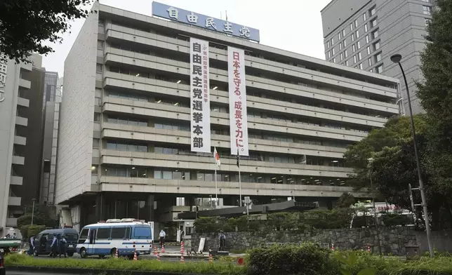 Police vehicles park near the headquarters of Japan's ruling Liberal Democratic Party in Tokyo after a man threw firebombs into the headquarters Saturday, Oct. 19, 2024. (Kyodo News via AP)