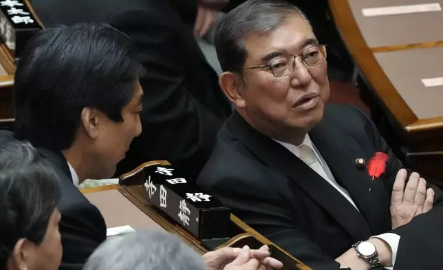 Japanese Prime Minister Shigeru Ishiba, right, speaks with other lawmakers prior to a Diet session at the Upper House of the Parliament Friday, Oct. 4, 2024, in Tokyo. (AP Photo/Eugene Hoshiko)