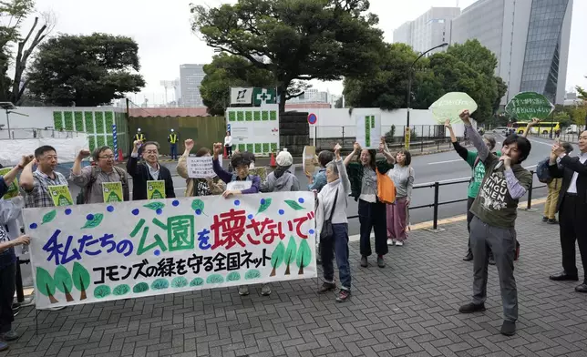 Protest leader Satoru Osawa, right, a Tokyo resident, speaks as environmentalists hold a rally near the Jingu Gaien park district of central Tokyo, Japan, as property developer Mitsui Fudosan begins cutting trees as part of the redevelopment of the area, Monday, Oct. 28, 2024. The banner reads, "Please don't destroy our park."(AP Photo/Hiro Komae)