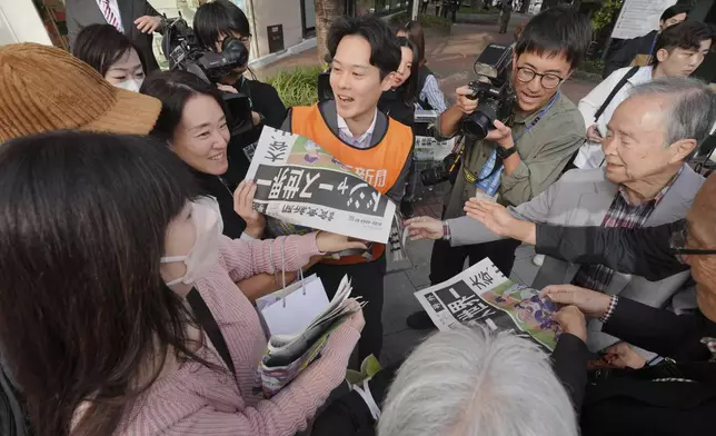 A staff member distributes an extra edition of the Yomiuri Shimbun newspaper in Tokyo, Thursday, Oct. 31, 2024, reporting on the Los Angeles Dodgers' victory in the World Series baseball match after the Dodgers defeated the New York Yankees in Game 5 in New York. The headline of the newspaper said "Dodgers is No. 1 in the World." (AP Photo/Eugene Hoshiko)