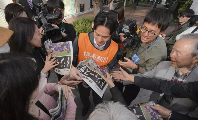 A staff member distributes an extra edition of the Yomiuri Shimbun newspaper in Tokyo, Thursday, Oct. 31, 2024, reporting on the Los Angeles Dodgers' victory in the World Series baseball match after the Dodgers defeated the New York Yankees in Game 5 in New York. The headline of the newspaper said "Dodgers is No. 1 in the World." (AP Photo/Eugene Hoshiko)