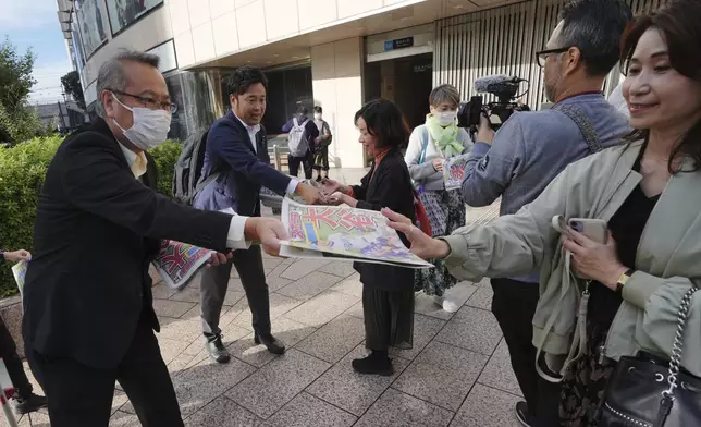 Staff members distribute copies of an extra edition of the Sports Nippon newspaper in Tokyo, Thursday, Oct. 31, 2024, reporting on the Los Angeles Dodgers' victory in the World Series baseball match after the Dodgers defeated the New York Yankees in Game 5 in New York. (AP Photo/Eugene Hoshiko)