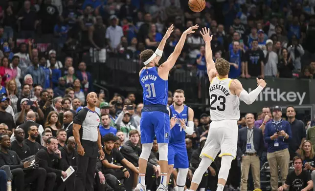 Dallas Mavericks guard Klay Thompson (31) takes a jump shot over Utah Jazz forward Lauri Markkanen (23) in the first half of an NBA basketball game, Monday, Oct. 28, 2024, in Dallas. (AP Photo/Albert Pena)