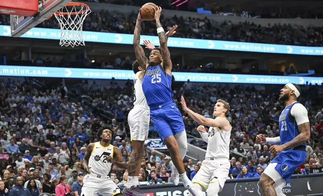 Dallas Mavericks forward P.J. Washington (25) goes up for a dunk in the second half as Utah Jazz forward Lauri Markkanen (23) watches during an NBA basketball game, Monday, Oct. 28, 2024, in Dallas. (AP Photo/Albert Pena)