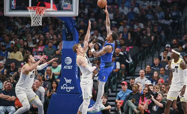 Dallas Mavericks forward P.J. Washington, center right, shoots a floating jump shot over Utah Jazz forward Lauri Markkanen, center left, in the first half of an NBA basketball game, Monday, Oct. 28, 2024, in Dallas. (AP Photo/Albert Pena)