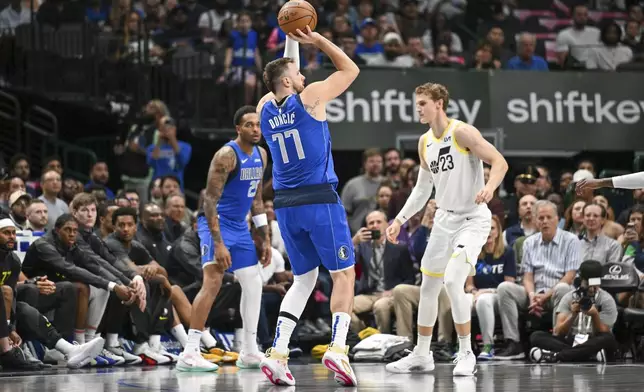 Dallas Mavericks guard Luka Doncic (77) takes a jump shot over Utah Jazz forward Lauri Markkanen (23) in the first half during an NBA basketball game, Monday, Oct. 28, 2024, in Dallas. (AP Photo/Albert Pena)