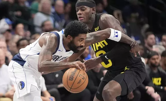 Dallas Mavericks guard Kyrie Irving, left, drives against Utah Jazz guard Jordan Clarkson, right, during the first half of a preseason NBA basketball game Thursday, Oct. 10, 2024, in Dallas. (AP Photo/LM Otero)