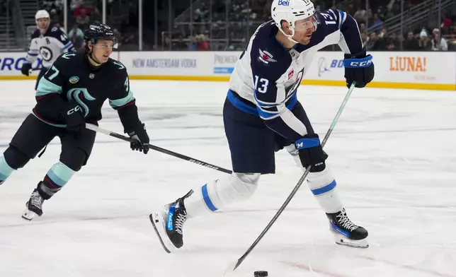 Winnipeg Jets center Gabriel Vilardi looks to shoot as Seattle Kraken center Yanni Gourde, left, looks on during the third period of an NHL hockey game Thursday, Oct. 24, 2024, in Seattle. (AP Photo/Lindsey Wasson)