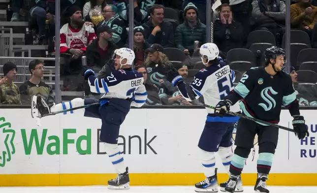 Winnipeg Jets left wing Nikolaj Ehlers, left, celebrates his game-winning goal with teammate Mark Scheifele (55) as Seattle Kraken defenseman Brandon Montour (62) looks away during overtime of an NHL hockey game Thursday, Oct. 24, 2024, in Seattle. The Jets won 4-3 in overtime. (AP Photo/Lindsey Wasson)