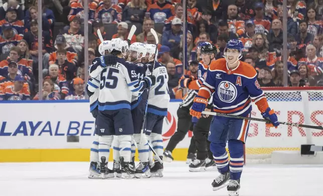 Winnipeg Jets players celebrate a goal as Edmonton Oilers' Ryan Nugent-Hopkins (93) reacts during second period NHL action in Edmonton, Alberta, Wednesday, Oct. 9, 2024. (Amber Bracken/The Canadian Press via AP)