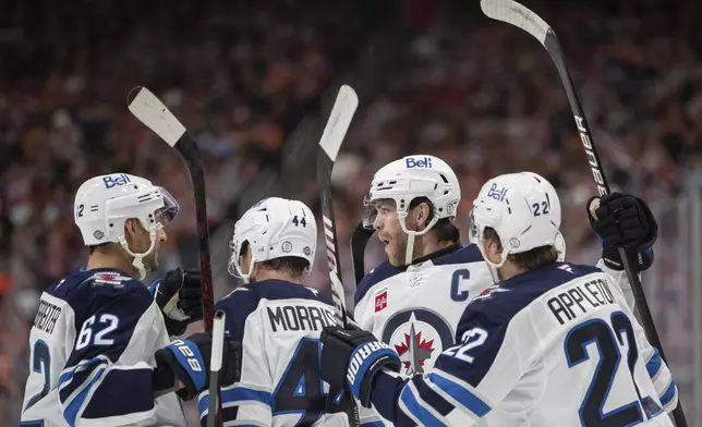 Winnipeg Jets' Adam Lowry, second right, celebrates his goal against the Edmonton Oilers with Nino Niederreiter (62) Josh Morrissey (44) and Mason Appleton (22) during the first period of an NHL hockey game, Wednesday, Oct. 9, 2024 in Edmonton, Alberta. (Amber Bracken/Canadian Press via AP)