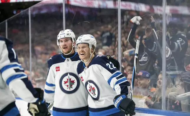 Winnipeg Jets' Mason Appleton (22) and Dylan Samberg (54) celebrate a goal against the Edmonton Oilers during the first period of an NHL hockey game, Wednesday, Oct. 9, 2024 in Edmonton, Alberta. (Amber Bracken/Canadian Press via AP)