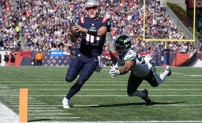 New England Patriots quarterback Drake Maye (10) runs for a touchdown in front of New York Jets linebacker Chazz Surratt (55) in the first half of an NFL football game, Sunday, Oct. 27, 2024, in Foxborough, Mass. (AP Photo/Michael Dwyer)