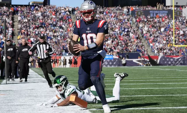 New England Patriots quarterback Drake Maye (10) runs into the end zone for a touchdown in front of New York Jets linebacker Chazz Surratt (55) in the first half of an NFL football game, Sunday, Oct. 27, 2024, in Foxborough, Mass. (AP Photo/Michael Dwyer)