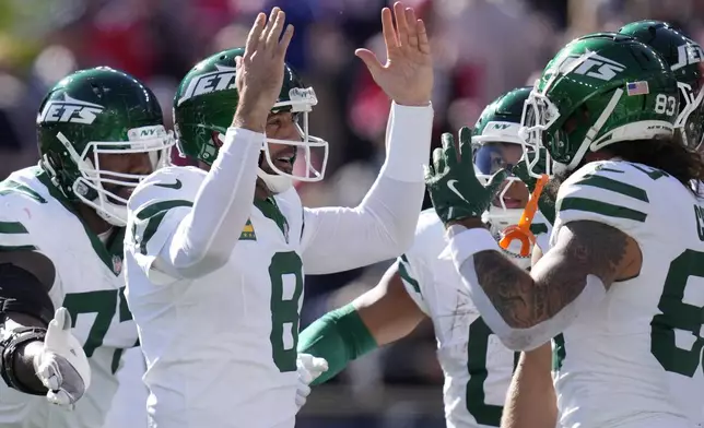 New York Jets quarterback Aaron Rodgers (8) celebrates with teammates including tight end Tyler Conklin (83) after throwing a touchdown pass in the first half of an NFL football game, Sunday, Oct. 27, 2024, in Foxborough, Mass. (AP Photo/Charles Krupa)