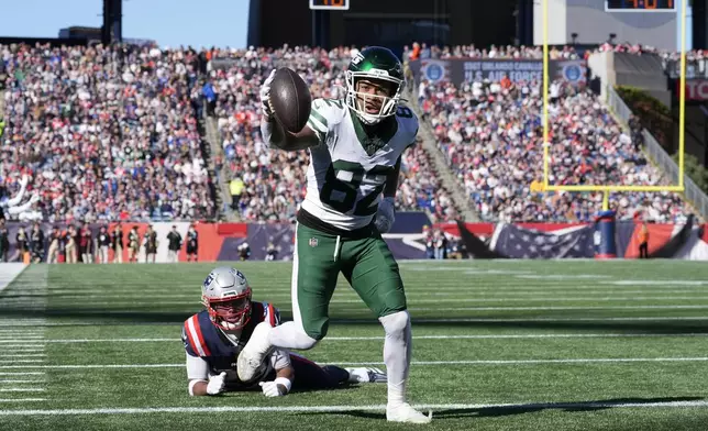 New York Jets wide receiver Xavier Gipson (82) celebrates his touchdown in front of New England Patriots cornerback Marcus Jones in the first half of an NFL football game, Sunday, Oct. 27, 2024, in Foxborough, Mass. (AP Photo/Michael Dwyer)