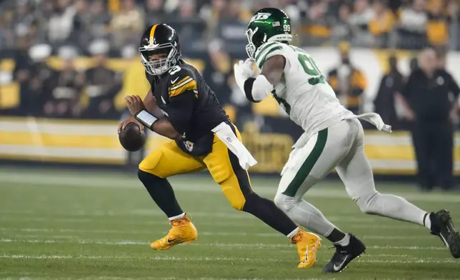 Pittsburgh Steelers quarterback Russell Wilson (3) scrambles from New York Jets defensive end Will McDonald IV (99) in the first half of an NFL football game in Pittsburgh, Sunday, Oct. 20, 2024. (AP Photo/Gene J. Puskar)