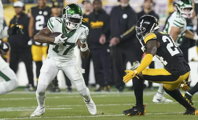 New York Jets wide receiver Davante Adams (17) pulls in a pass reception against Pittsburgh Steelers cornerback Joey Porter Jr. (24) in the first half of an NFL football game in Pittsburgh, Sunday, Oct. 20, 2024. (AP Photo/Matt Freed)