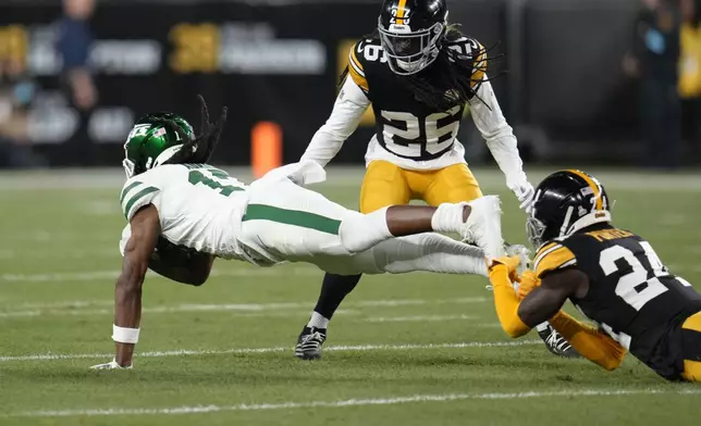 New York Jets wide receiver Davante Adams (17) is tackled by Pittsburgh Steelers cornerback Joey Porter Jr. (24) in the first half of an NFL football game in Pittsburgh, Sunday, Oct. 20, 2024. (AP Photo/Gene J. Puskar)