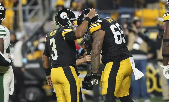 Pittsburgh Steelers quarterback Russell Wilson (3) celebrates his touchdown with offensive tackle Dan Moore Jr. (65) in the second half of an NFL football game against the New York Jets in Pittsburgh, Sunday, Oct. 20, 2024. (AP Photo/Matt Freed)