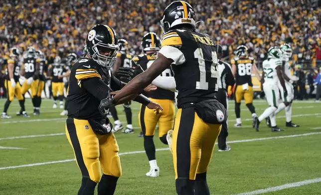 Pittsburgh Steelers wide receiver George Pickens (14) celebrates his touchdown reception against New York Jets with Pittsburgh Steelers quarterback Russell Wilson (3) the first half of an NFL football game in Pittsburgh, Sunday, Oct. 20, 2024. (AP Photo/Matt Freed)