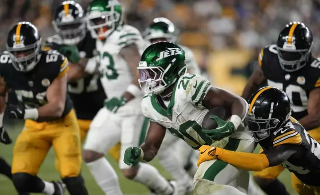 New York Jets running back Breece Hall (20) carries against Pittsburgh Steelers cornerback Joey Porter Jr. (24) in the second half of an NFL football game in Pittsburgh, Sunday, Oct. 20, 2024. (AP Photo/Gene J. Puskar)