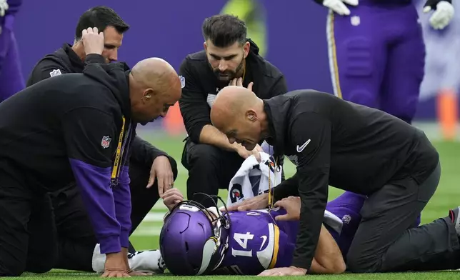 Medical staff attend to Minnesota Vikings quarterback Sam Darnold during the first half of an NFL football game against the New York Jets, Sunday, Oct. 6, 2024, at the Tottenham Hotspur stadium in London. (AP Photo/Kirsty Wigglesworth)