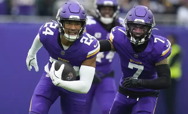 Minnesota Vikings' Camryn Bynum, left, celebrates an interception during the first half of an NFL football game against the New York Jets, Sunday, Oct. 6, 2024, at the Tottenham Hotspur stadium in London. (AP Photo/Kirsty Wigglesworth)