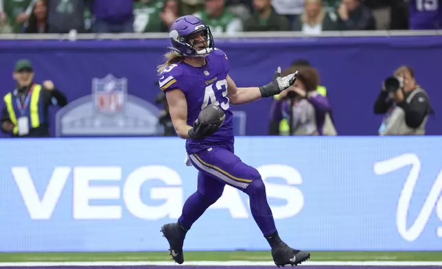 Minnesota Vikings' Andrew Van Ginkel celebrates as he scores after an interception during the first half of an NFL football game against the New York Jets, Sunday, Oct. 6, 2024, at the Tottenham Hotspur stadium in London. (AP Photo/Ian Walton)