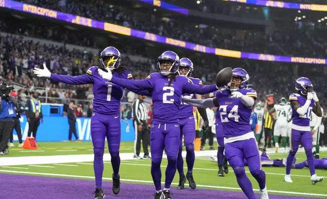 Minnesota Vikings' Stephon Gilmore (2), center, celebrates after an interception during the second half of an NFL football game against the New York Jets, Sunday, Oct. 6, 2024, at the Tottenham Hotspur stadium in London. (AP Photo/Kirsty Wigglesworth)