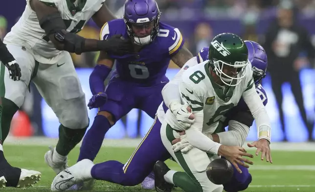 New York Jets quarterback Aaron Rodgers (8), right, is sacked by Minnesota Vikings' Harrison Phillips during the second half of an NFL football game, Sunday, Oct. 6, 2024, at the Tottenham Hotspur stadium in London. (AP Photo/Ian Walton)