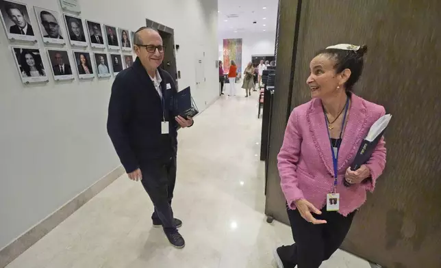 Craig Berko, left, director of membership at Temple Beth Sholom, chats with senior rabbi Gayle Pomerantz as she prepares to start a Shabbat service, Friday, Sept. 27, 2024, in Miami Beach, Fla. (AP Photo/Wilfredo Lee)