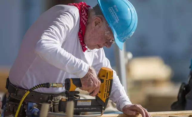 FILE - Former President Jimmy Carter works with other volunteers on site during the first day of the weeklong Jimmy &amp; Rosalynn Carter Work Project, their 35th work project with Habitat for Humanity, in Mishawaka, Ind., Aug. 27, 2018. (Robert Franklin/South Bend Tribune via AP, File)