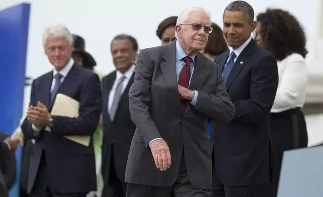 FILE - Former President Jimmy Carter pulls notes out of his pocket before delivering remarks during a ceremony commemorating the 50th anniversary of the March on Washington at the Lincoln Memorial in Washington, Aug. 28, 2013. (AP Photo/Evan Vucci, File)