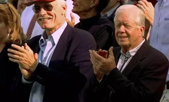 FILE - Former President Jimmy Carter, right, and Atlanta Braves team owner Ted Turner, left, watch early play during Game 6 of the National League Championship Series in Atlanta, Oct. 14, 1998. (AP Photo/Pat Sullivan, File)