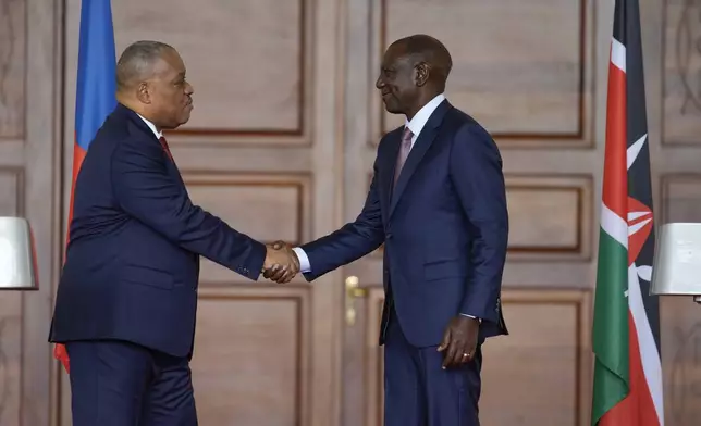 Haiti Prime Minister Garry Conille, left, and Kenya's President William Ruto, right, shake hands after a joint at State House in Nairobi, Kenya, Friday, Oct. 11, 2024. (AP Photo/Brian Inganga)