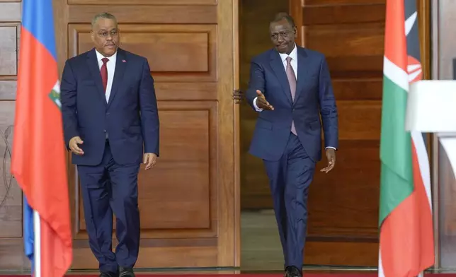 Haiti Prime Minister Garry Conille, left, and Kenya's President William Ruto, right, walk to give a joint press conference during their meeting at State House in Nairobi, Kenya, Friday, Oct. 11, 2024. (AP Photo/Brian Inganga)